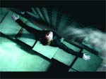 A person in dark clothing lies with arms spread wide on a set of teal-colored stairs.