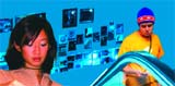 A woman in the foreground and a man in a yellow shirt and blue beanie in a blue-lit room with wall photos.