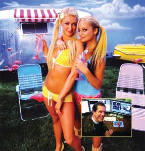 Two women in colorful swimwear holding drinks, posing in front of a silver camper and lawn chairs.