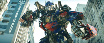 A massive blue and red mechanical robot towering between urban skyscrapers.