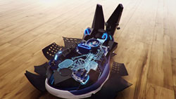 A futuristic black and blue mechanical device with glowing blue lights sits on a light wood floor.